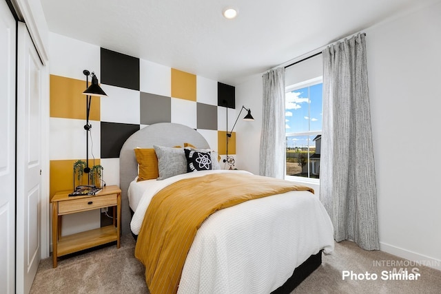 carpeted bedroom featuring a closet and baseboards