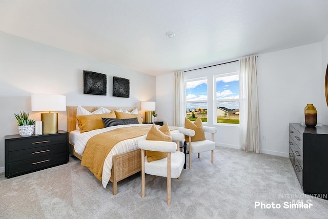 bedroom with baseboards and light carpet