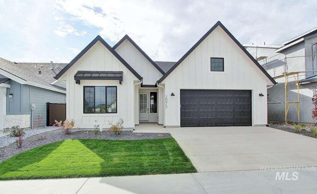 modern inspired farmhouse featuring a garage and a front yard