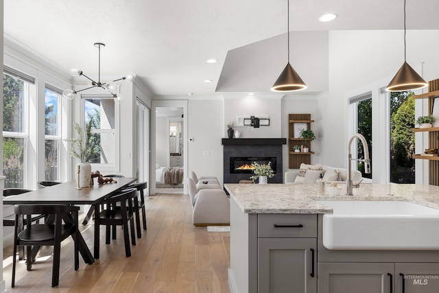 3051 S Sedgebrook Ln, Eagle, ID 83616 - kitchen with a sink, gray cabinetry, a chandelier, light wood-style floors, and light stone counters