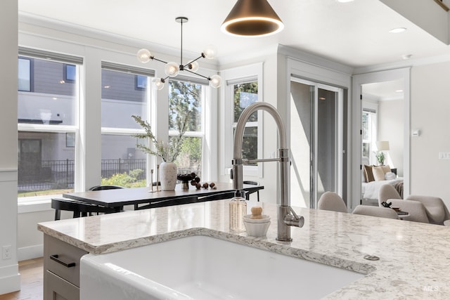 3051 S Sedgebrook Ln, Eagle, ID 83616 - kitchen with a sink, light stone countertops, pendant lighting, light wood-style floors, and crown molding