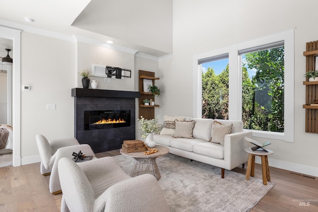 3051 S Sedgebrook Ln, Eagle, ID 83616 - living room with a tile fireplace, light wood-type flooring, baseboards, and a towering ceiling