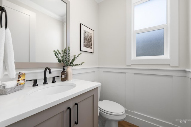 3051 S Sedgebrook Ln, Eagle, ID 83616 - bathroom featuring vanity, toilet, wainscoting, and a decorative wall