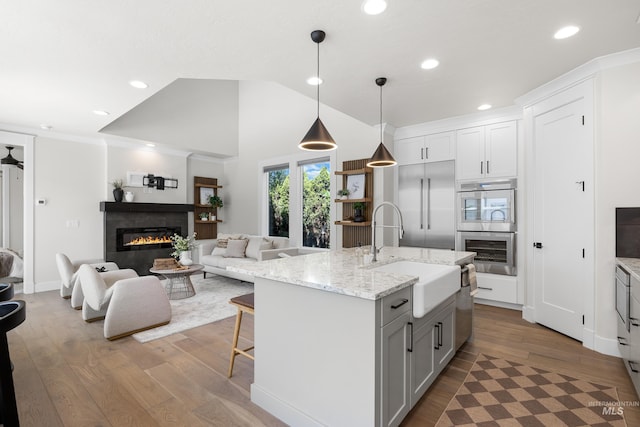 3051 S Sedgebrook Ln, Eagle, ID 83616 - kitchen with a sink, wood finished floors, open floor plan, recessed lighting, and a kitchen island with sink