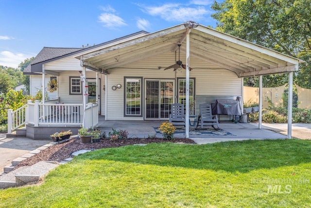 view of front of house featuring a patio, a front lawn, roof with shingles, and ceiling fan