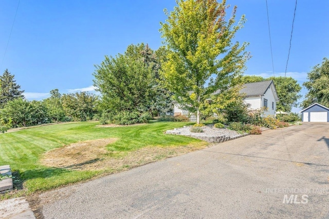 view of yard with a detached garage and an outbuilding