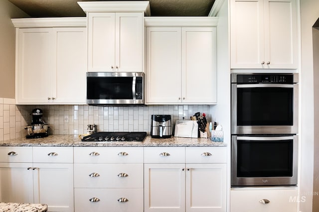 1234 W Sagwon Dr, Kuna, ID 83634 - kitchen featuring appliances with stainless steel finishes, white cabinetry, and backsplash