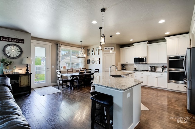 1234 W Sagwon Dr, Kuna, ID 83634 - kitchen with appliances with stainless steel finishes, a sink, recessed lighting, decorative backsplash, and light stone countertops