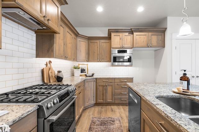 10685 W Evelia St, Boise, ID 83709 - kitchen featuring stainless steel appliances, under cabinet range hood, light wood finished floors, brown cabinets, and light stone countertops