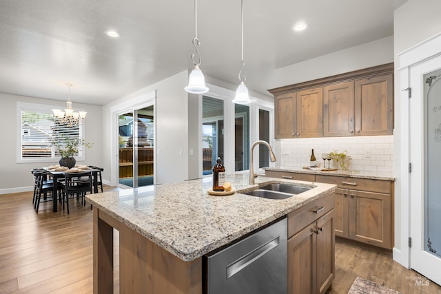 10685 W Evelia St, Boise, ID 83709 - kitchen with dishwasher, tasteful backsplash, wood finished floors, a center island with sink, and decorative light fixtures