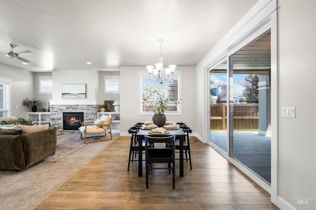 10685 W Evelia St, Boise, ID 83709 - dining area with a chandelier, a fireplace, wood finished floors, and a ceiling fan