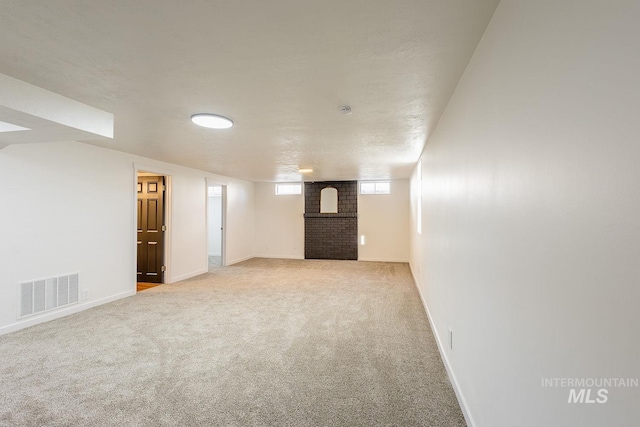 basement with carpet and a fireplace