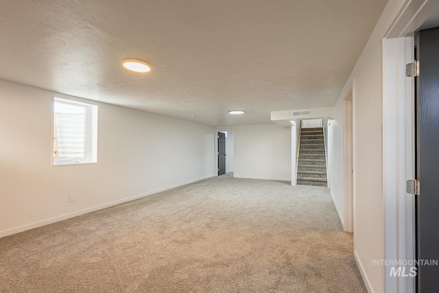 basement with light carpet and a textured ceiling