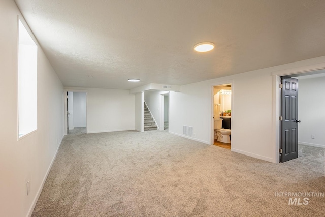 basement with carpet floors and a textured ceiling