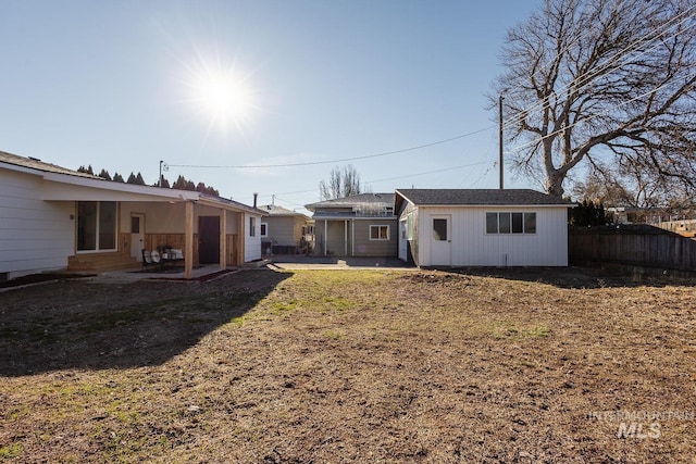 back of house with a lawn and a patio