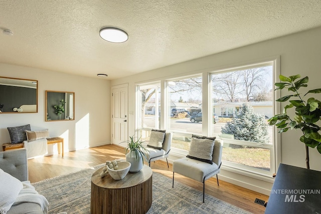 living room featuring light hardwood / wood-style floors and a textured ceiling