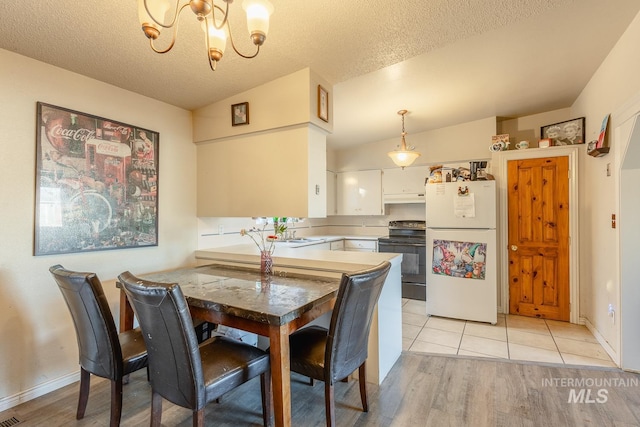 dining area featuring an inviting chandelier, sink, light hardwood / wood-style flooring, and a textured ceiling