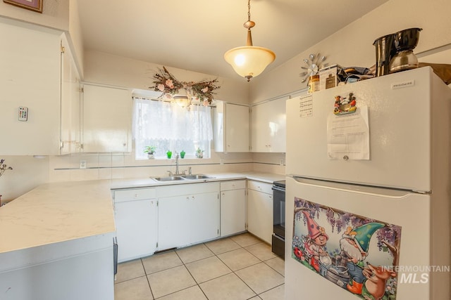 kitchen featuring range with electric cooktop, decorative light fixtures, white cabinetry, sink, and white fridge