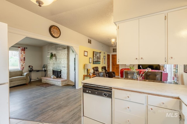 kitchen with white cabinetry, dishwasher, a textured ceiling, and light hardwood / wood-style flooring