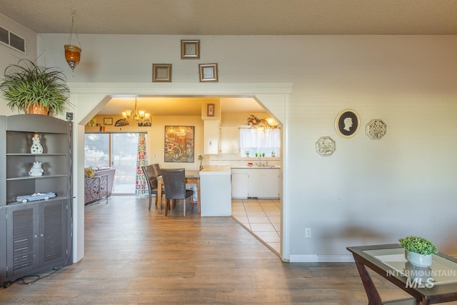 dining area featuring a chandelier, sink, and light hardwood / wood-style flooring