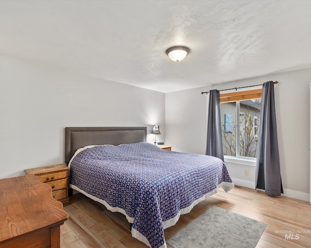 bedroom featuring baseboards and light wood-type flooring