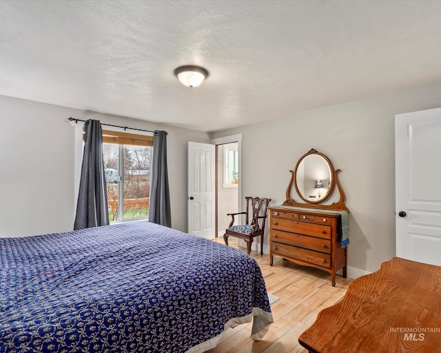 bedroom with light wood-type flooring and baseboards