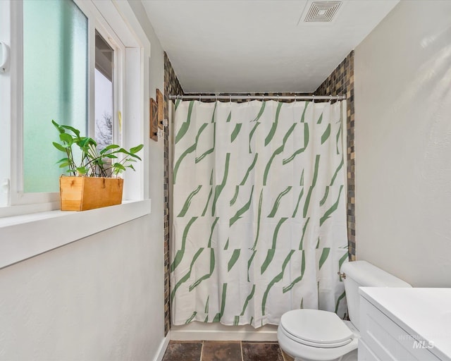 bathroom with visible vents, shower / bath combo with shower curtain, toilet, stone finish floor, and vanity