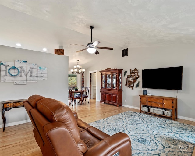 living room with light wood-style floors, ceiling fan with notable chandelier, visible vents, and lofted ceiling