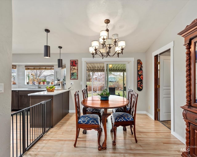 dining room featuring an inviting chandelier, plenty of natural light, and light wood finished floors