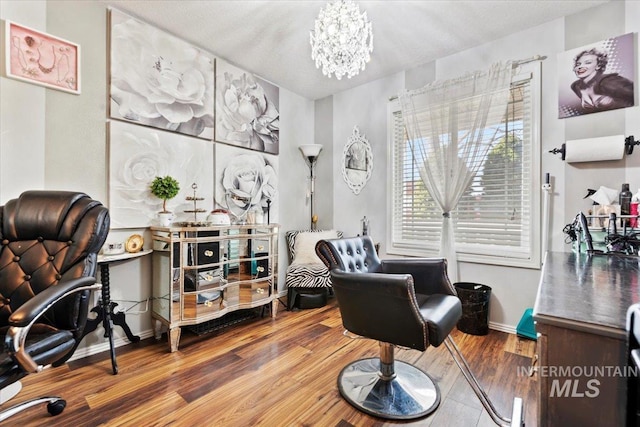 sitting room featuring hardwood / wood-style floors and an inviting chandelier