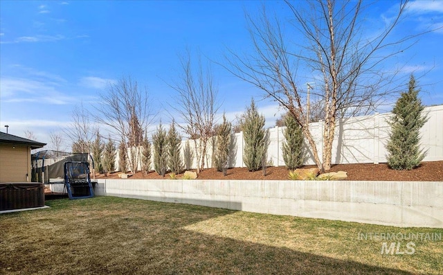 view of yard featuring a fenced backyard, cooling unit, and a trampoline