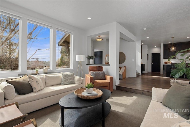 living area with carpet, recessed lighting, and a textured ceiling