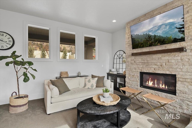 carpeted living room with baseboards and a large fireplace