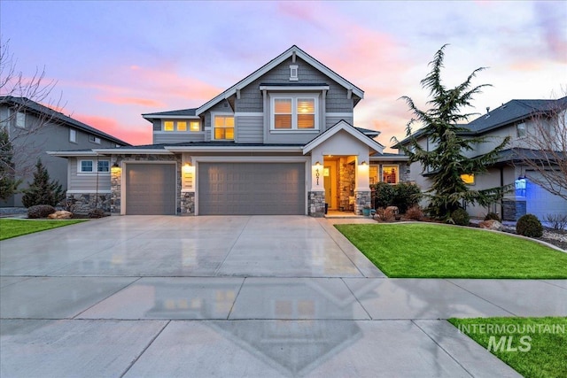 craftsman-style home with stone siding, an attached garage, driveway, and a front lawn