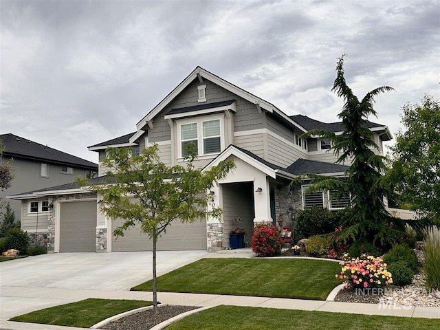 craftsman inspired home with an attached garage, stone siding, driveway, and a front lawn