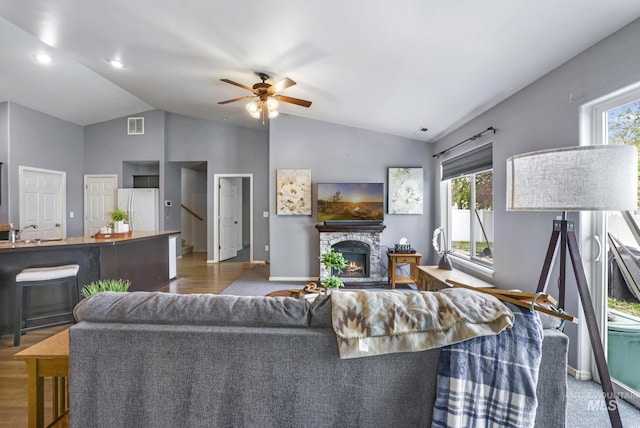 1517 Elm St N, Jerome, ID 83338 - living area featuring lofted ceiling, a ceiling fan, a stone fireplace, baseboards, and wood finished floors