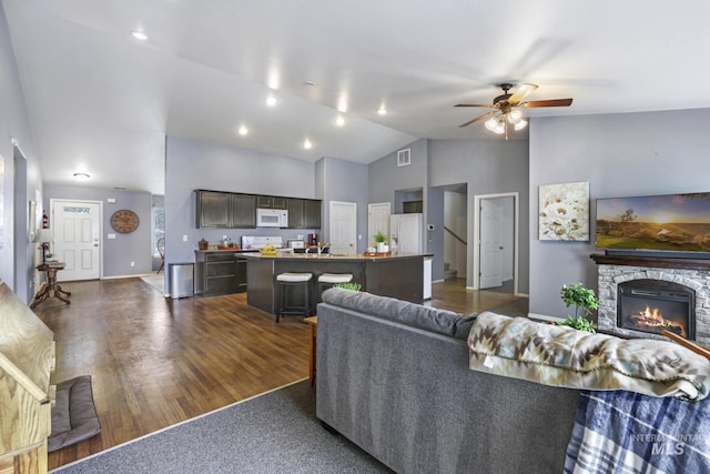 1517 Elm St N, Jerome, ID 83338 - living area featuring a ceiling fan, lofted ceiling, dark wood-style flooring, a stone fireplace, and baseboards
