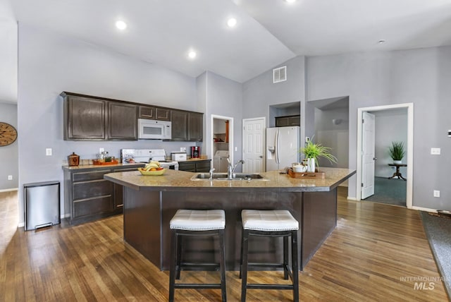 1517 Elm St N, Jerome, ID 83338 - kitchen with white appliances, a sink, high vaulted ceiling, dark brown cabinetry, and baseboards
