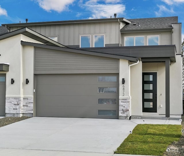 view of front of home with stone siding, board and batten siding, and concrete driveway