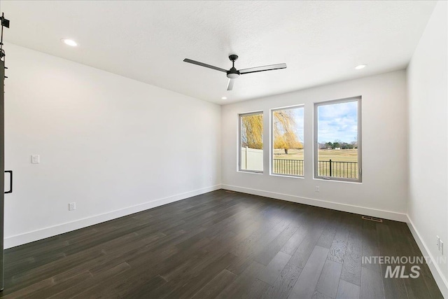 spare room with dark wood-style floors, recessed lighting, visible vents, ceiling fan, and baseboards