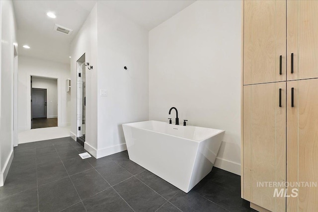 full bath with a freestanding tub, visible vents, baseboards, and tile patterned floors