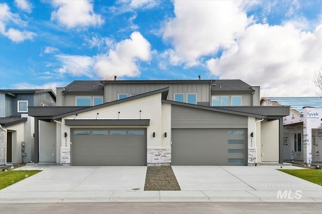 view of front facade featuring stone siding, concrete driveway, and board and batten siding