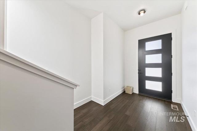 entrance foyer featuring dark wood finished floors, visible vents, and baseboards