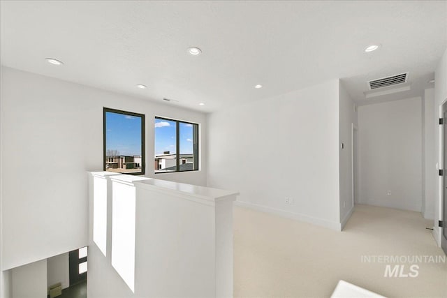 hallway with visible vents, baseboards, an upstairs landing, and recessed lighting