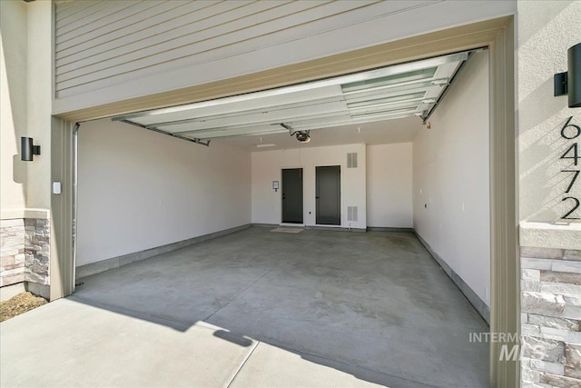 garage with a garage door opener and baseboards