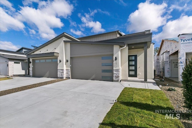 view of front of property featuring a garage, driveway, and stucco siding