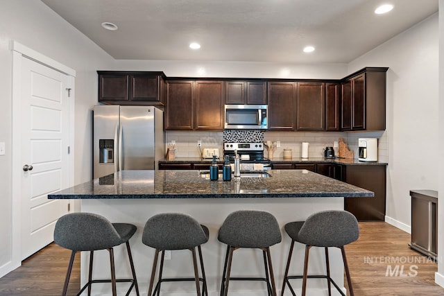1873 W American Fork Dr, Meridian, ID 83642 - kitchen with appliances with stainless steel finishes, a sink, a kitchen breakfast bar, dark brown cabinetry, and recessed lighting