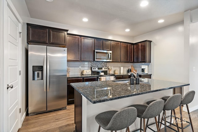 1873 W American Fork Dr, Meridian, ID 83642 - kitchen with appliances with stainless steel finishes, a sink, light wood-type flooring, dark brown cabinets, and recessed lighting