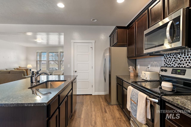 1873 W American Fork Dr, Meridian, ID 83642 - kitchen with stainless steel appliances, a sink, dark wood-style floors, dark brown cabinetry, and tasteful backsplash