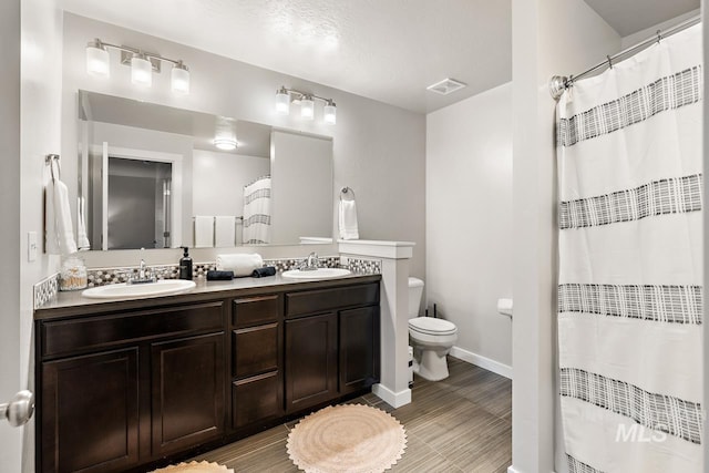 1873 W American Fork Dr, Meridian, ID 83642 - full bath featuring double vanity, toilet, curtained shower, baseboards, and wood finished floors